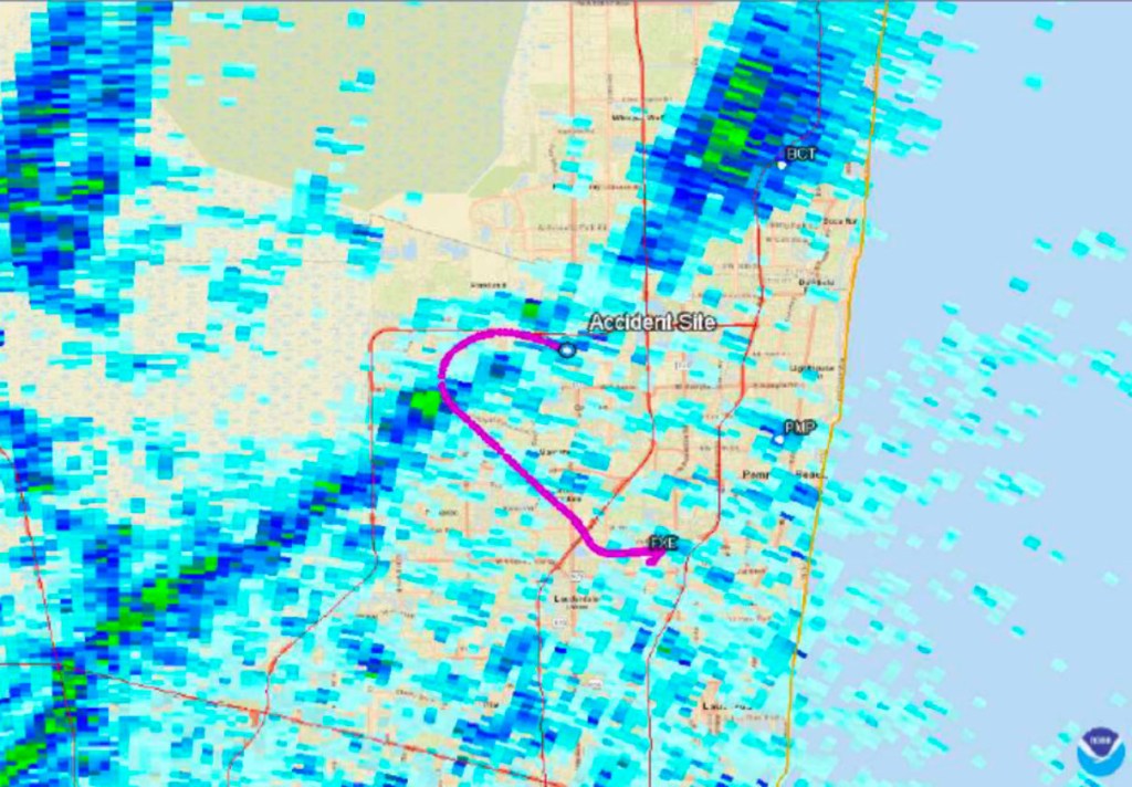 Illustration of a flight path in magenta over a radar weather map with light to heavy rain, an accident site, and locations labeled BCT, PMP, and FXE.